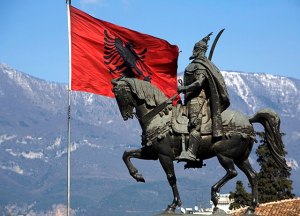 La statua dell'eroe nazionale albanese Giorgio Castriota Skanderbeg, accanto alla bandiera della terra delle Aquile.